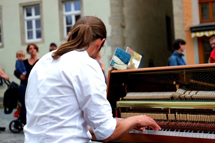 young man at piano outside