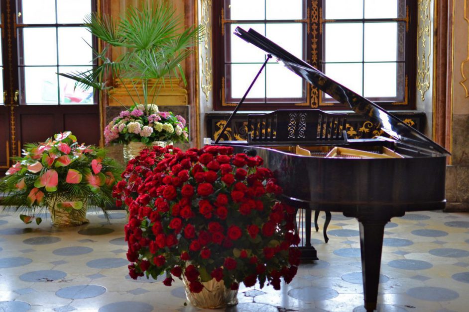 flowers near dark baby grand piano