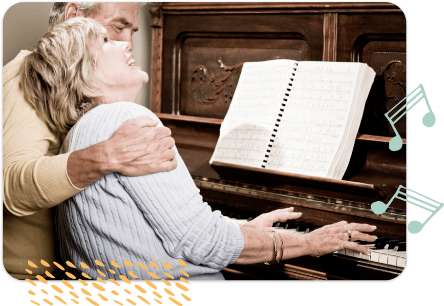 Senior man and woman happily play the piano together