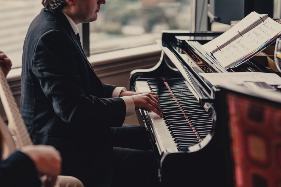 man in suit at piano